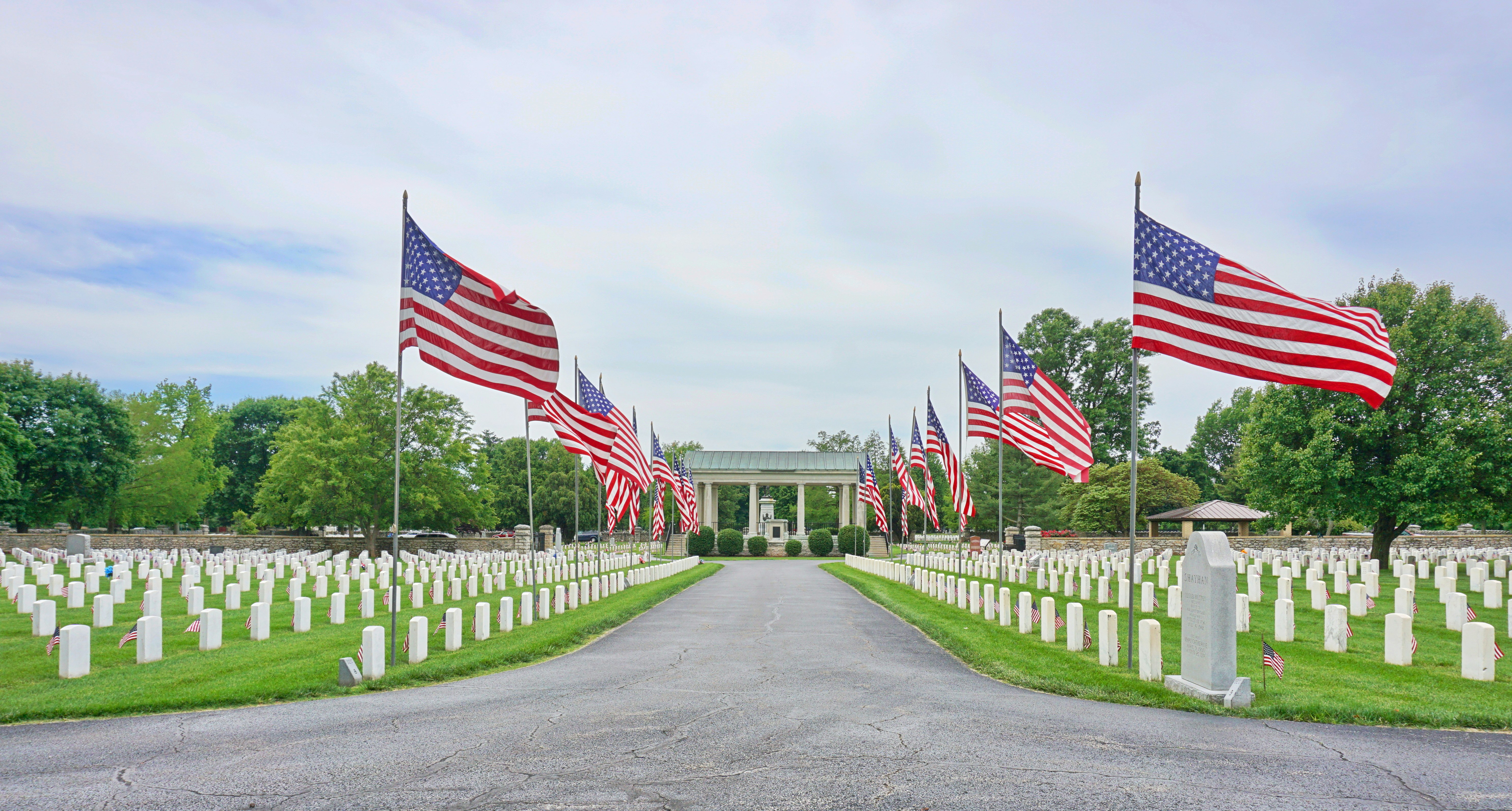 us a flags on green grass field under white cloudy sky during daytime